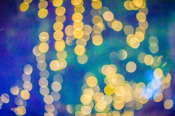 Beautiful yellow bokeh abstract light background. Wonderful Defocused abstract yellow christmas background. Abstract christmas lights as background in the night with noise grain and poor light.