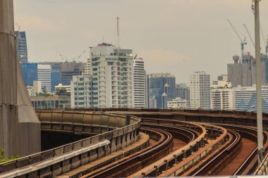 Bina inşaat şehir arka planda orman üzerinde yükseltilmiş demiryolu eğrisi. Sermaye city, metropolis ve geliştirme kavramı.