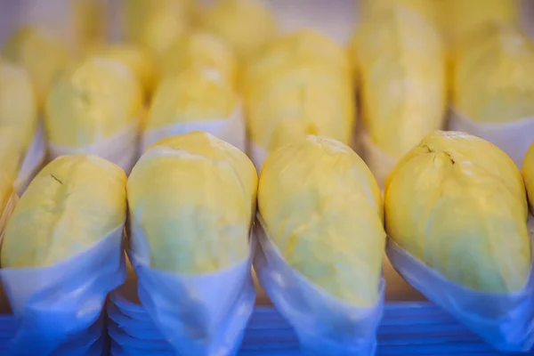 Peeled durian for sale at the fruit market. Durian flesh packed with an exposed seed on sale at the fresh market. Durian is a popular tropical fruit in south east asia.