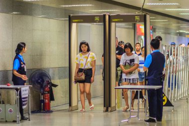 Bangkok, Tayland - 23 Nisan 2017: Yolcu güvenlik personeli ile pass ile metal detektörü kemer ve tam vücut tarayıcı erişim önce metro istasyonuna anti-terör politikası çerçevesinde yürüyor.