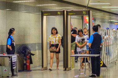 Bangkok, Tayland - 23 Nisan 2017: Yolcu güvenlik personeli ile pass ile metal detektörü kemer ve tam vücut tarayıcı erişim önce metro istasyonuna anti-terör politikası çerçevesinde yürüyor.