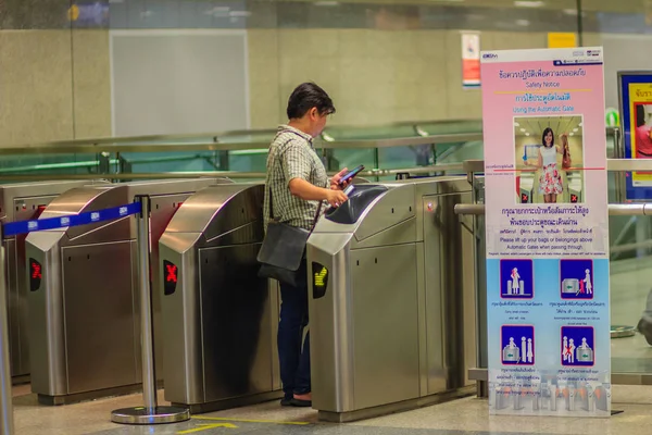 Bangkok, Tayland - 23 Nisan 2017: Tanımlanamayan yolcu kullanım sikke bilet dokunmatik Chatuchak Mrt (Metropolitan hızlı Transit) metro istasyonuna girmek için otomatik erişim engeli ile.