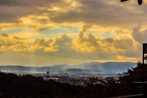 京都市の都市を雲の切れ間から輝く太陽光線 背景に劇的な曇り空と太陽梁清水寺から京都市内の眺め — ストック写真