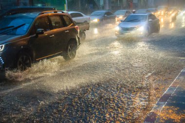 Bangkok, Tayland - 6 Temmuz. 2017: araba ile şiddetli yağmur akşamları. Rating ile dolu düşük görünürlük, kaygan ve sıçramasına su ile tehlikeli durumda ağır yağmur altında.