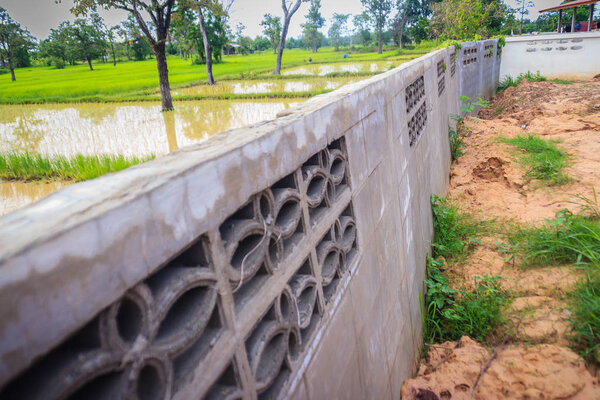 Fence wall of the newly built housing is tilted and collapsed due to high earthwork and heavy rainfall, causing the soil in the house to weaken and flow out with the water although there are drains. 