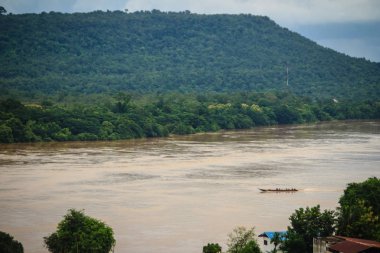 Uzun kuyruklu bir tekne tam yolcular ile çamurlu Amphoe Khong Chiam, en doğudaki bölge Ubon Ratchathani Tayland Eyaleti, Mekong Nehri boyunca nehir gelgit karşı ters yönde çalışıyor.
