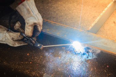Kaynakçı aşınma koruyucu el eldiven elektrot tutarak ve kaynak metal ve sparks. Kaynak bir üretim veya malzeme, genellikle metal veya termoplastik katıldı heykel süreç olduğunu.