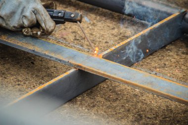 Kaynakçı aşınma koruyucu el eldiven elektrot tutarak ve kaynak metal ve sparks. Kaynak bir üretim veya malzeme, genellikle metal veya termoplastik katıldı heykel süreç olduğunu.