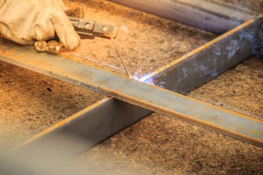 Kaynakçı aşınma koruyucu el eldiven elektrot tutarak ve kaynak metal ve sparks. Kaynak bir üretim veya malzeme, genellikle metal veya termoplastik katıldı heykel süreç olduğunu.