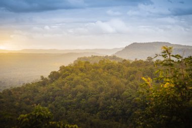 Huzurlu manzara yeşil orman ve gündoğumu veya günbatımı dağlar Pakse, Champasak, Laos üzerinden. Atış Wat Sirindhorn Wararam Phu Prao, Ubon Ratchathani, Tayland, Thailand, Chong Mek sınır yakınlaştırır