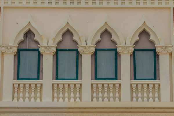 Row of arch windows on the balcony with stucco wall background.