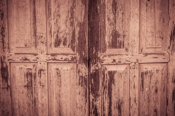 Old ancient wooden swing door background. Vintage of old wooden folding doors texture. Antique swing doors or folding doors at old wooden commercial building.