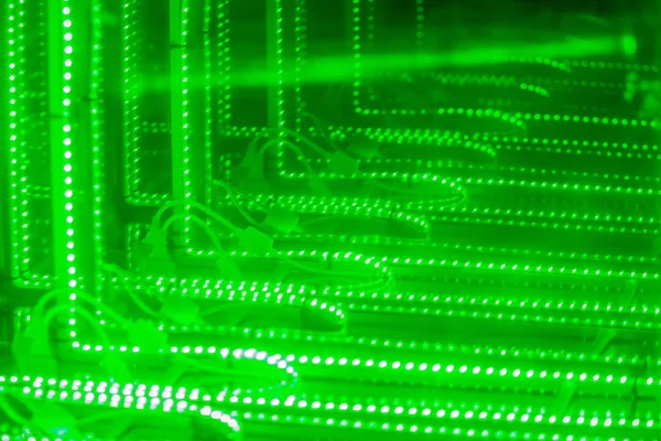 Abstract futuristic green led lights background. Blinking green neon lights unfocused background. Blurry of bokeh light, shimmering blur spot lights on green abstract background.