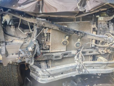 Yakın çekim yeni gümüş renkli araba kaza ile bozuk önü. Kaza yeni gümüş renkli araba ağır hasarlı ve onarım ve kaybı ayarlamak için araba sigorta tazminat talebi için çağrı garaja taşımak için yardıma ihtiyacı.