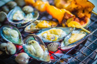 Mürekkep, midye ve istiridye üzerinde gece partide soba kömür ızgara. Deniz ürünleri Barbekü partisi ile kalamar calamaris, midye ve istiridyeler ateşe ızgara. Barbekü kavramı, seçici odak.