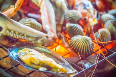 Kadar ızgara yengeçler kapatın ve istiridye üzerinde gece partide soba kömür ateş. Deniz ürünleri Barbekü partisi ile Yengeç ve istiridye ateşe ızgara. Deniz ürünleri Barbekü kavramı, seçici odak.