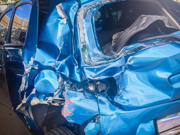 事故で歪んだ青い新しい車の前にクローズ アップ クラッシュした新しい青い車は深刻な破損し 修復し 車の保険金請求のため損失アジャスターに呼び出す駐車場への移動のための助けが必要 — ストック写真