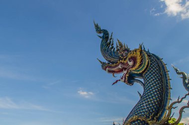 Güzel mavi naga heykel mavi gökyüzü ve güneşli beyaz bulut genel tapınağında Wat Rong Sua on, Chiang Rai, Tayland. Naga Budizm tapınaklarda buldum çok büyük bir yılan olduğunu.