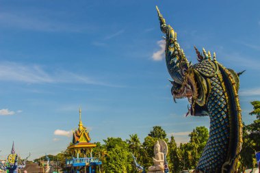 Güzel mavi naga heykel mavi gökyüzü ve güneşli beyaz bulut genel tapınağında Wat Rong Sua on, Chiang Rai, Tayland. Naga Budizm tapınaklarda buldum çok büyük bir yılan olduğunu.