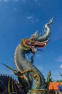 Güzel mavi naga heykel mavi gökyüzü ve güneşli beyaz bulut genel tapınağında Wat Rong Sua on, Chiang Rai, Tayland. Naga Budizm tapınaklarda buldum çok büyük bir yılan olduğunu.