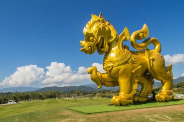 Chiang Rai, Tayland - 19 Kasım 2017: Altın aslan heykeli logosu altında Boonrod çiftlik veya singha Park mavi gökyüzü ve bulutlar beyaz arka plan, Chiang Rai ünlü tarım turizm cazibe.