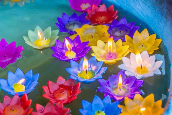 Colorful lotus flower with burning candles are floating on the water to worship the Buddha with pray blessings at at Wat Rong Suea Ten Temple, also known as the Blue Temple, Chiang Rai, Thailand.