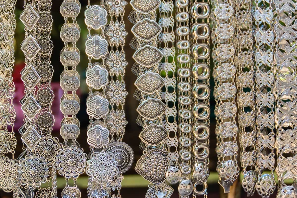 Beautiful vintage silver belts pattern detailed in thai style fashion for women in the antique market. Shop for souvenir handcraft belt as vintage fashion at the local market in Chiang Rai, Thailand.