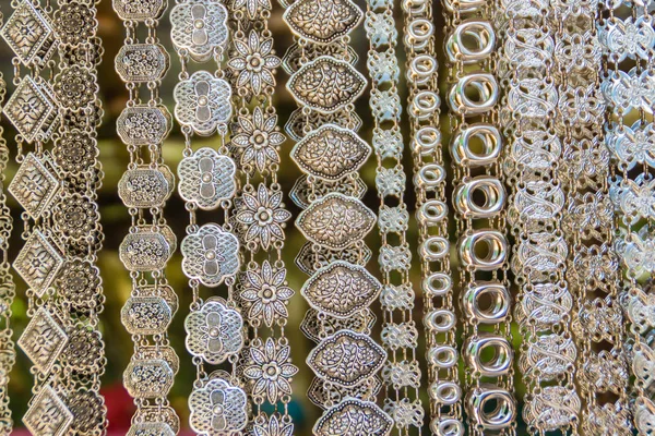 Beautiful vintage silver belts pattern detailed in thai style fashion for women in the antique market. Shop for souvenir handcraft belt as vintage fashion at the local market in Chiang Rai, Thailand.