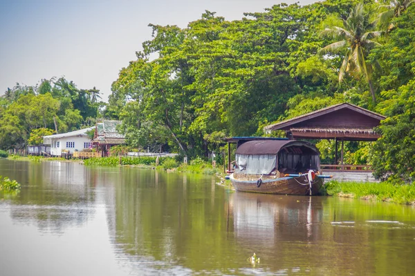 Attractive boat house on the river bank and the countryside scenery along Tha Chin river (Maenam Tha Chin), Nakhon Pathom, Thailand
