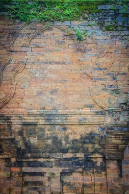 Eski harabe tuğla duvar yeşil yosun ve küçük çim kaplı. Tuğla duvar eski khmer kutsal yeşil yosun ile büyümüş.