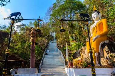 Wat Khao Rup Chang veya Tapınağı fil Hill, bir Phichit ili, Tayland en ünlü konumlar Hill'deki merdiven giderken sarı big Buddha.