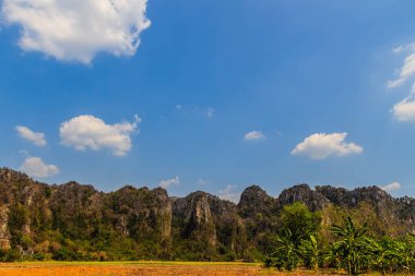 Manzaralı kalker Dağları aralığı ve mavi gökyüzü arka plan ile Ban Mung Köyü, Noen Maprang bölgesi, Phitsanulok Eyaleti, Tayland, hasat sonra pirinç alan çiftçi Hut.