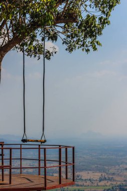 Ağaç dalı ile mavi gökyüzü ve bulutlar beyaz arka plan üzerinde ahşap salıncak asmıştı.