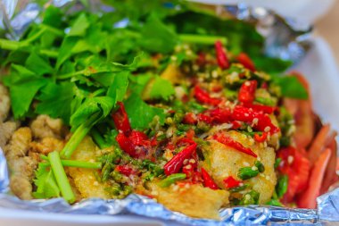 Domuz eti salata alüminyum folyo ile kaplanır. Alüminyum folyo arka plan üzerinde balık salatası.