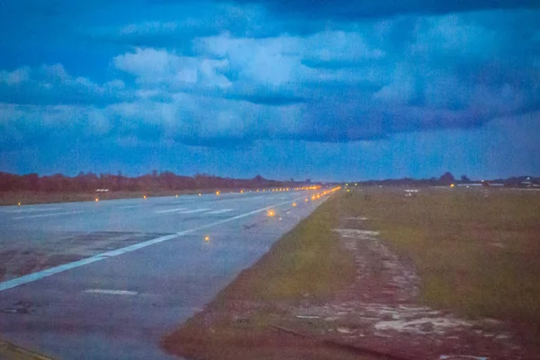 Final approach to landing and taking-off on a runway in the evening flight. Skid marks on at the airport runway after sunset.