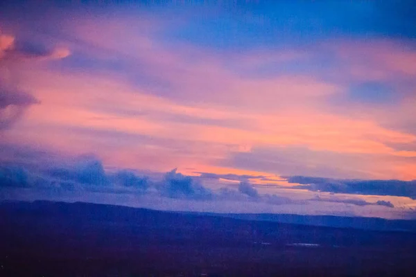 Dusk sky and cloud at morning dawn background. Vibrant colors of the sky with clouds from dusk till dawn. Dramatic evening cloudscape in the city. Twilight sky began to change from blue to orange.