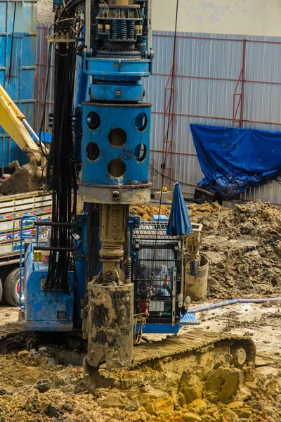 Hydraulic drilling machine is boring holes in the construction site for bored piles work. Bored piles are reinforced concrete elements cast into drilled holes, also known as replacement piles.