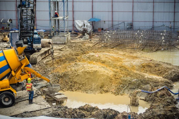 Wet concrete pour or pump from the concrete lorry into the bore pile casing. Bored piles are piles where the removal of spoil forms a hole for a reinforced concrete pile which is poured in situ.