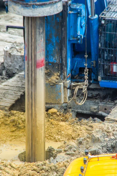 Hydraulic drilling machine is boring holes in the construction site for bored piles work. Bored piles are reinforced concrete elements cast into drilled holes, also known as replacement piles.