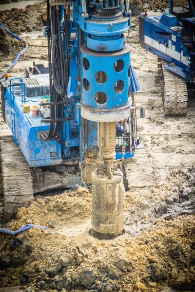 Hydraulic drilling machine is boring holes in the construction site for bored piles work. Bored piles are reinforced concrete elements cast into drilled holes, also known as replacement piles.