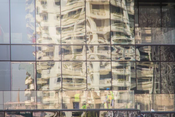 现代化的摩天大楼建筑与玻璃反映工人在建筑工地 建筑施工人员对办公楼的抽象反思 — 图库照片