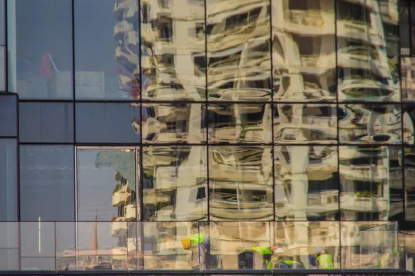 现代化的摩天大楼建筑与玻璃反映工人在建筑工地 建筑施工人员对办公楼的抽象反思 — 图库照片