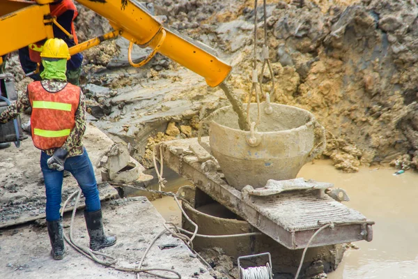Wet concrete pour or pump from the concrete lorry into the bore pile casing. Bored piles are piles where the removal of spoil forms a hole for a reinforced concrete pile which is poured in situ. — Stock Image Wet Concrete Pour Pump Concrete Lorry Bore Pile Casing Bored Royalty Free Stock Photos