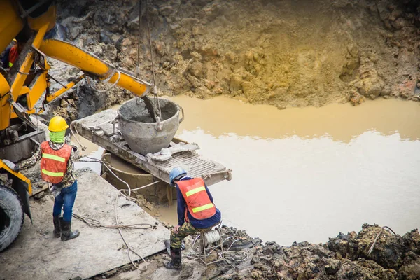 Wet concrete pour or pump from the concrete lorry into the bore pile casing. Bored piles are piles where the removal of spoil forms a hole for a reinforced concrete pile which is poured in situ. — Stock Image Wet Concrete Pour Pump Concrete Lorry Bore Pile Casing Bored Stock Image