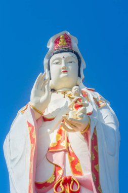 Dev beyaz Guanyin heykeli mavi gökyüzü arka plan ile. Guanyin veya Guan Yin Mahayana Budistler ve Çin Halk dinler, bir Doğu Asya bodhisattva olarak da bilinen 