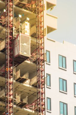 İnşaat işçileri yarım kalmış binaların inşaat alanına taşıma amaçlı bina yüksek asansörde. Yolcu ve malzeme taşıma platformu dikey nakliye için-adam ve malzeme kaldırma.