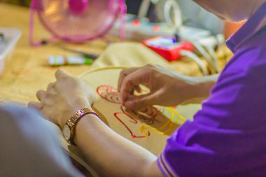 Nakış çember ve iğne ile evde iken adamın elini kapatın. Nakış kumaş veya diğer malzemeler ya da halka çerçeve ile iplik uygulamak için bir iğne kullanarak dekorasyon zanaat olduğunu.