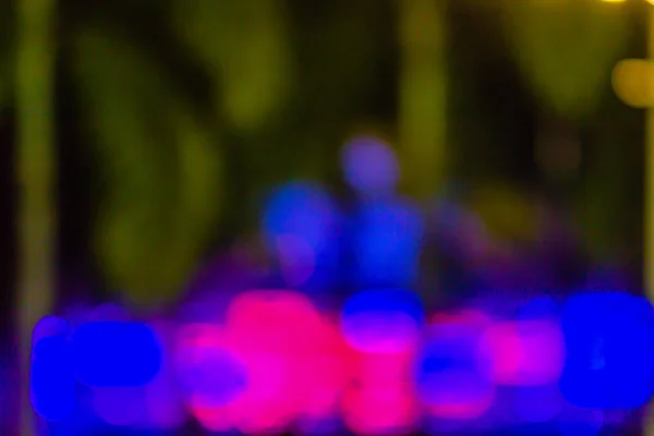 Blurred light with bokeh background of temple fair in Thailand. Walking street market with blurred people and bokeh light. Abstract blurred circular bokeh background.