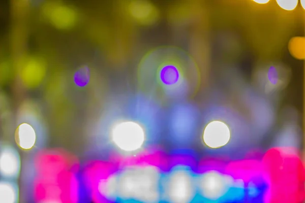 Blurred light with bokeh background of temple fair in Thailand. Walking street market with blurred people and bokeh light. Abstract blurred circular bokeh background.