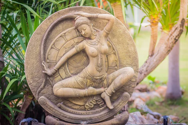 Thai mother earth (Phra Mae Thorani) fountain statue at the public park. She is the goddess that wringing the water of detachment out of her hair to drown demon to protect Buddha before enlightenment.